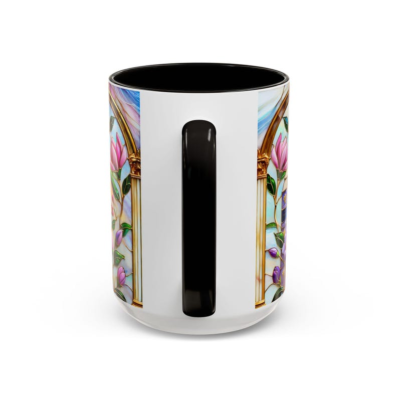 May include: White ceramic mug with a black interior and handle. The mug features a stained-glass design with pink and purple flowers, gold accents, and a blue sky background. The design wraps around the mug.