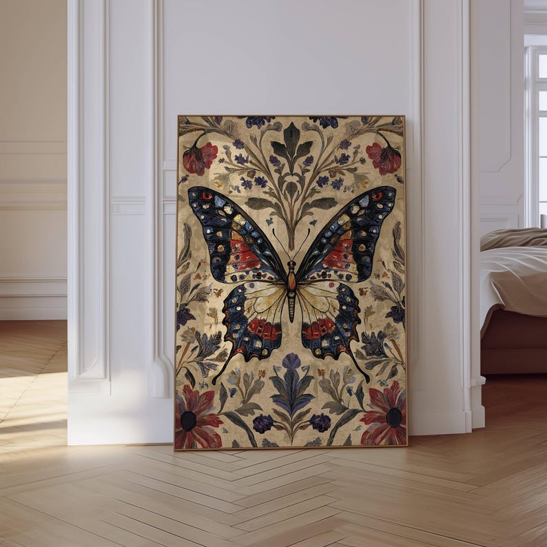 Puede incluir: Una impresi&oacute;n art&iacute;stica enmarcada de una mariposa. La mariposa tiene un cuerpo crema y alas con detalles rojos, azules y negros. El fondo es de color dorado con patrones florales y de hojas. La obra de arte se exhibe en una habitaci&oacute;n con piso de madera.
