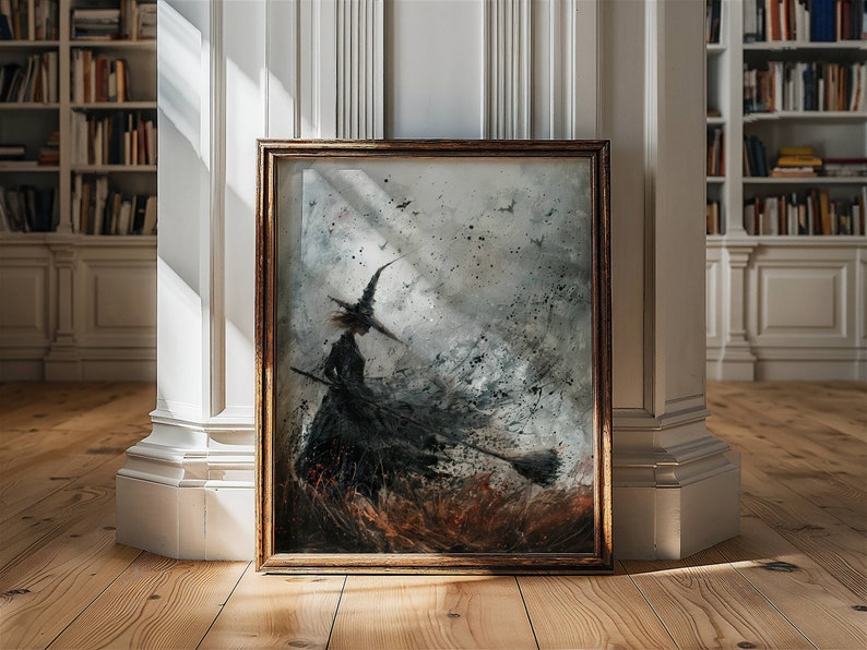 May include: A framed painting of a witch flying on a broomstick in a stormy sky. The witch is silhouetted against a background of swirling gray and white clouds. The painting is in a dark wood frame.