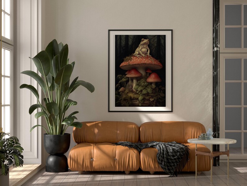 May include: A framed print of a frog sitting on a red and white mushroom in a forest setting.