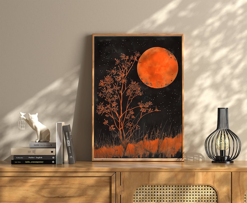 Peut inclure: Une impression encadr&eacute;e d'une peinture &agrave; l'aquarelle noire et orange d'un arbre avec une grande lune orange en arri&egrave;re-plan.
