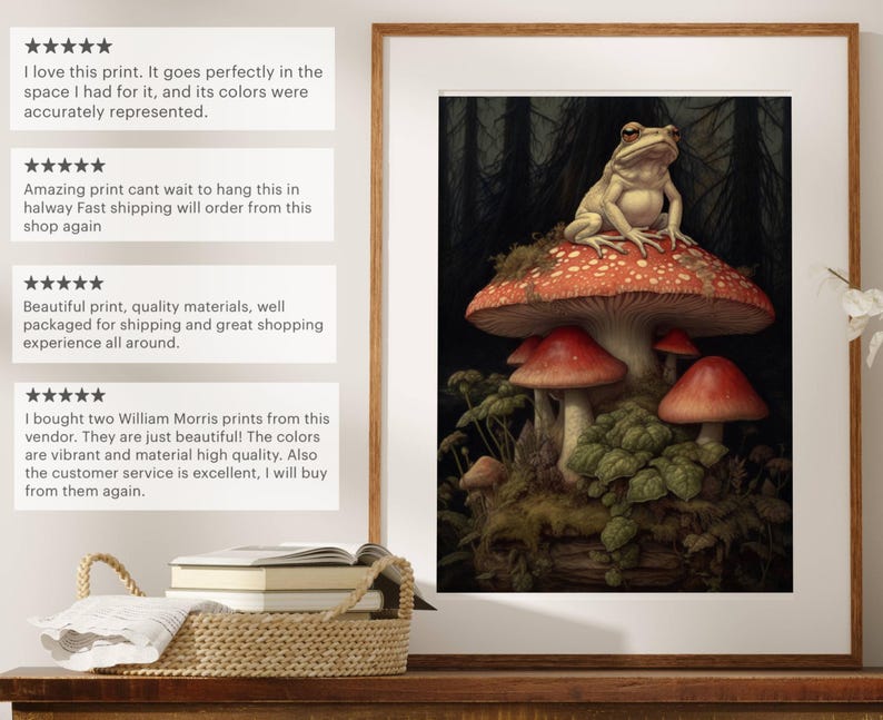 May include: A framed print of a frog sitting on a red mushroom in a dark forest setting. The print is surrounded by a wooden frame.
