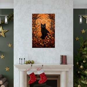 May include: A black cat with bright yellow eyes sits in a forest of orange and brown leaves. The cat is surrounded by leaves and the background is a blurred image of trees.