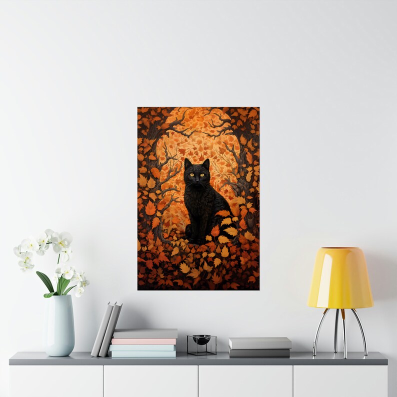 May include: A black cat with yellow eyes sits in a forest of orange and brown leaves. The cat is looking directly at the viewer.