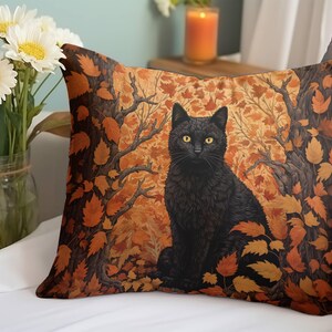 May include: A black cat with yellow eyes sits in a forest of orange and brown leaves. The cat is looking directly at the viewer. The background is a dark brown with a pattern of leaves.