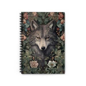 May include: A gray wolf's face is surrounded by lush green leaves and pink and white flowers. The wolf's eyes are a bright yellow.