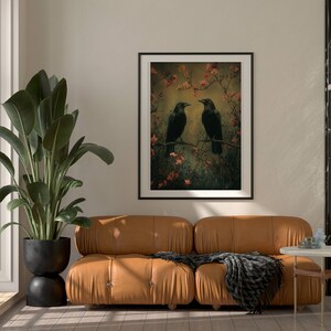 May include: A framed print of two black crows perched on branches with pink blossoms. The background is a soft, muted green and brown.
