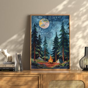 May include: Watercolor painting of a nighttime forest scene with a campfire, tent, and a large moon. Tall evergreen trees frame the scene under a starry sky. The artwork is framed in a wooden frame and displayed on a wooden cabinet.