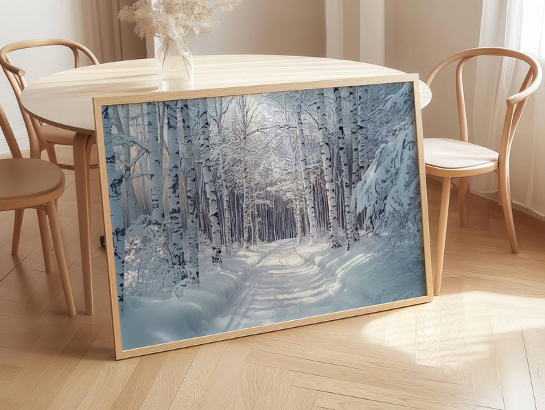 Puede incluir: Impresi&oacute;n enmarcada de un paisaje invernal con un camino cubierto de nieve que serpentea por un bosque de abedules. La obra de arte muestra una escena serena con nieve blanca, sombras azules y un marco dorado, evocando tranquilidad.