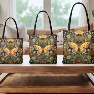 May include: Three tote bags with black handles and a floral pattern featuring a yellow butterfly. The bags are arranged in size order from smallest to largest on a wooden table.
