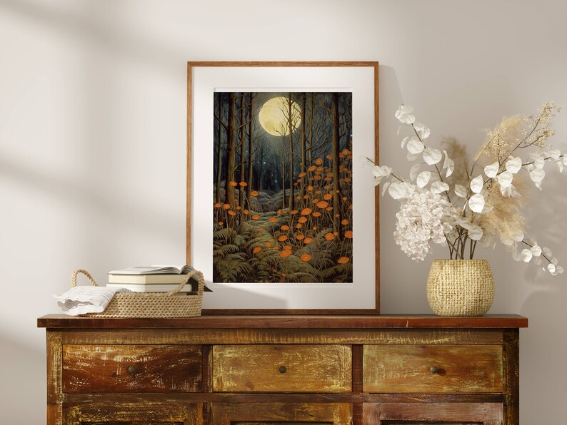 May include: A framed print of a moonlit forest scene with a path leading through the trees. The trees are dark green and the moon is a bright yellow. There are orange mushrooms growing along the path.