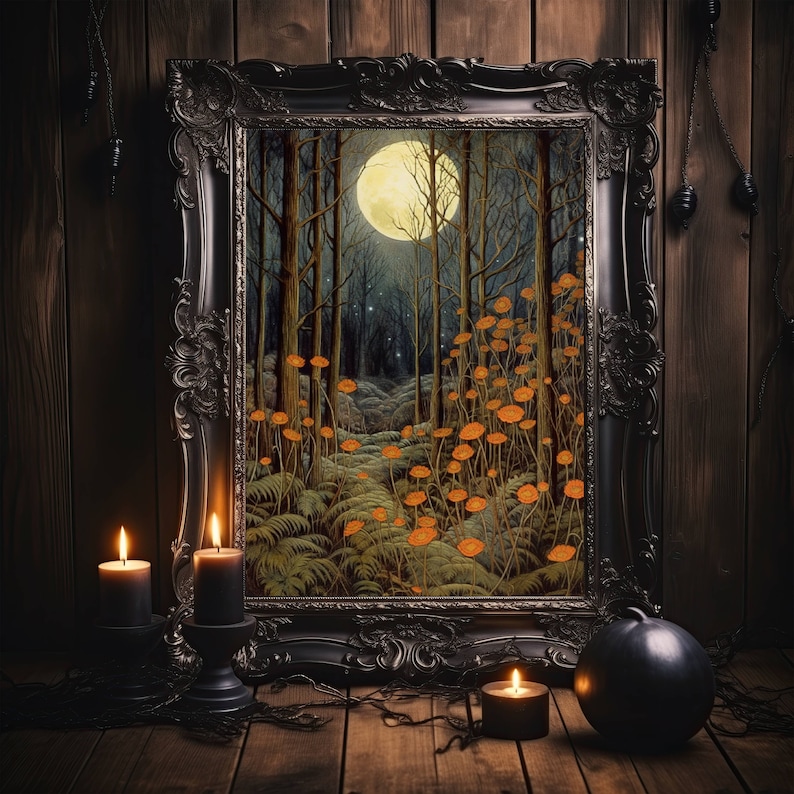 May include: A black framed picture with a forest scene inside. The forest is lit by a full moon and there are orange flowers growing in the forest. The picture is sitting on a wooden surface with candles and a black orb.