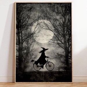 K&ouml;nnte beinhalten: Gerahmter Schwarz-Wei&szlig;-Druck, der eine Hexe auf einem Fahrrad vor einem Vollmond in einem Wald zeigt. Die Hexe tr&auml;gt einen spitzen Hut und einen Umhang. Das Kunstwerk hat eine Vintage- und gruselige &Auml;sthetik.