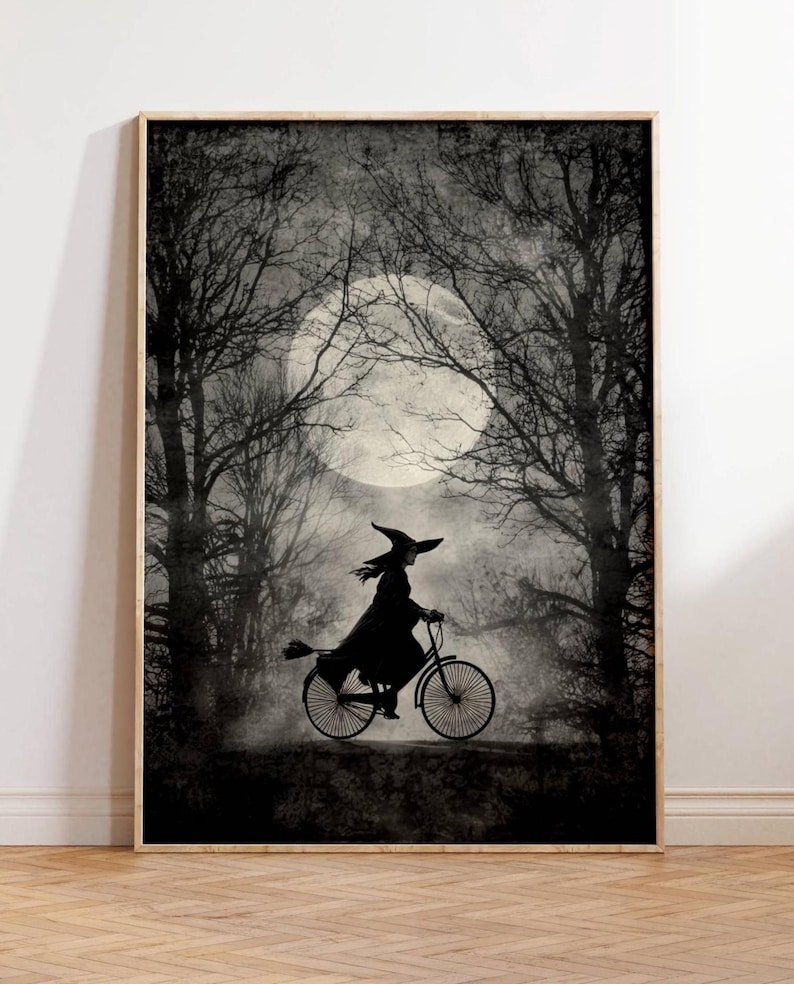 K&ouml;nnte beinhalten: Gerahmter Schwarz-Wei&szlig;-Druck, der eine Hexe auf einem Fahrrad vor einem Vollmond in einem Wald zeigt. Die Hexe tr&auml;gt einen spitzen Hut und einen Umhang. Das Kunstwerk hat eine Vintage- und gruselige &Auml;sthetik.