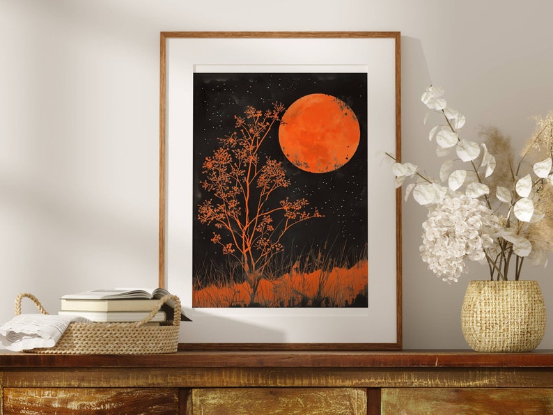 This gorgeous poster print features an illustration of an orange full moon above a matching orange tree, with orange grass  in the foreground. The sky is black and full of tiny stars.