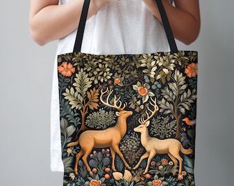 Puede incluir: Una bolsa de tela negra con un estampado floral que presenta dos ciervos en un entorno de bosque. Los ciervos son marrones y dorados con cuernos. Las flores son de tonos rosa, rojo y amarillo.