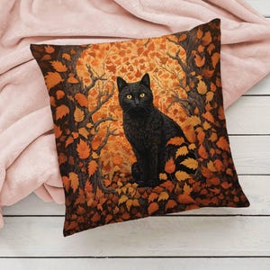 May include: A black cat with yellow eyes sits in a forest of orange and brown leaves. The cat is looking directly at the viewer. The background is a dark brown with a hint of green.