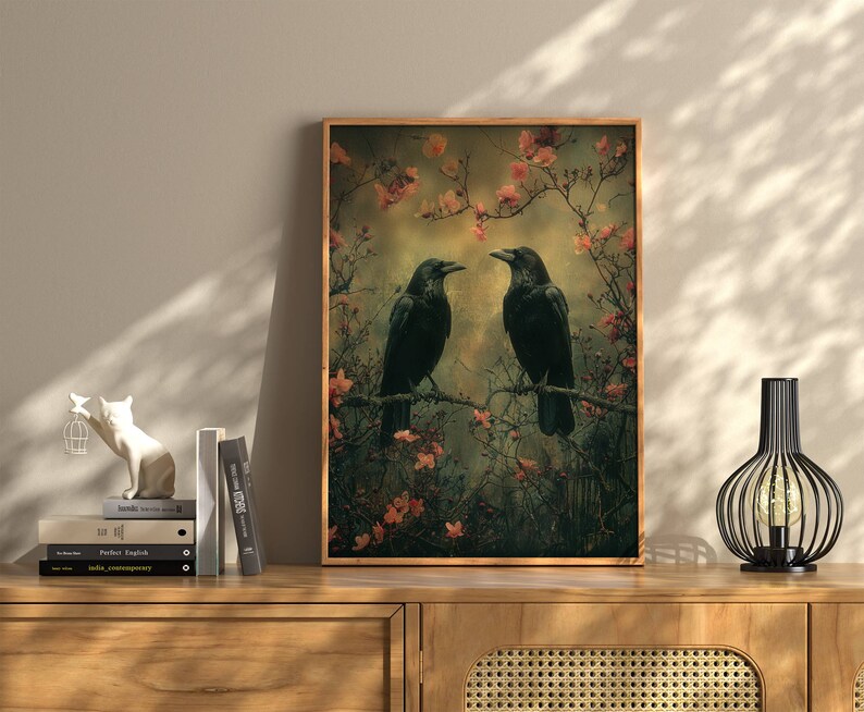 May include: A framed print of two black crows perched on branches in a forest setting. The crows are facing each other and appear to be communicating. The background is a soft, muted green with pink blossoms.
