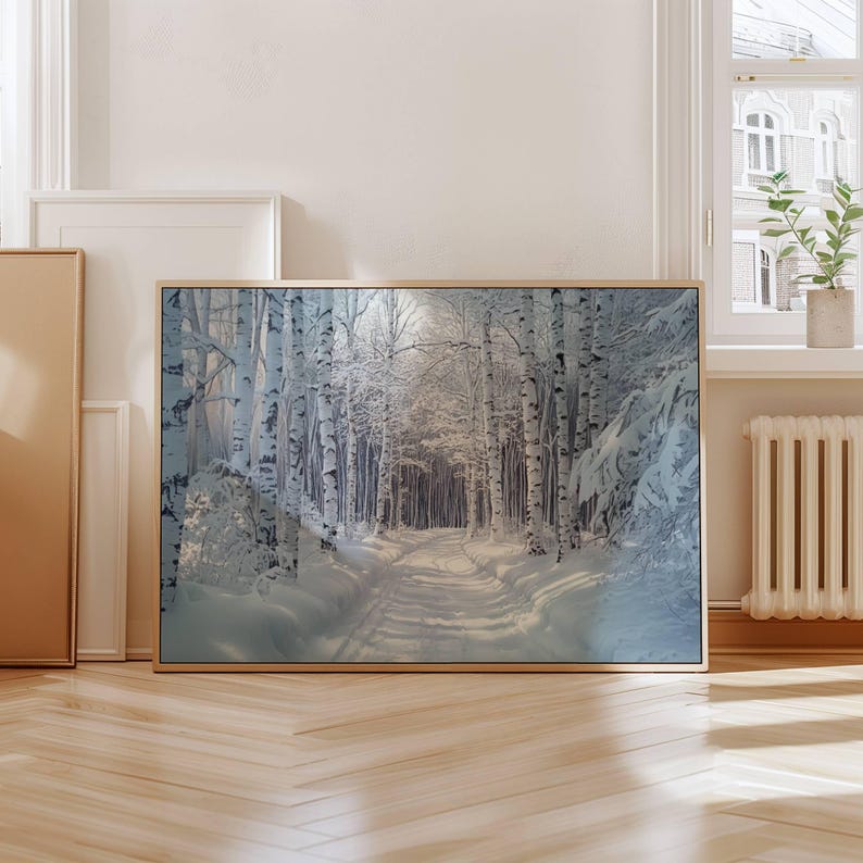 Puede incluir: Una impresi&oacute;n art&iacute;stica enmarcada que representa un paisaje de bosque nevado. El camino serpentea a trav&eacute;s de un bosque de abedules, con sus troncos blancos destacando sobre la nieve. La impresi&oacute;n est&aacute; en un marco de madera clara.