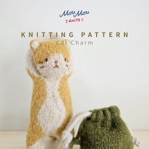 Puede incluir: Un amuleto de gato tejido con hilo amarillo mostaza y crema, junto a una pequeña bolsa de color verde oliva con cordón. El texto dice Mou Mou KNITS KNITTING PATTERN Cat Charm. El gato tiene rasgos faciales bordados y brazos alzados.