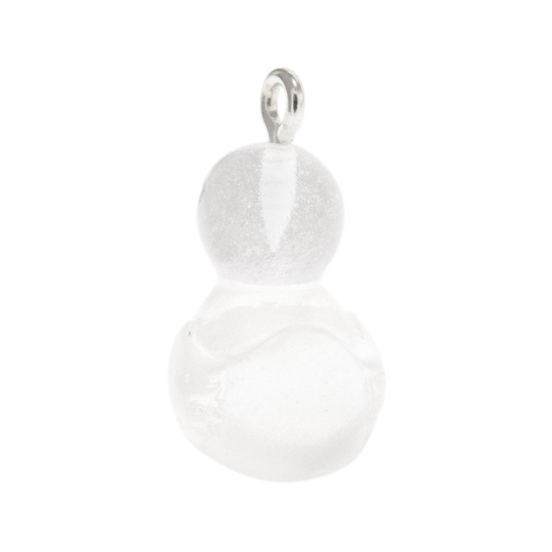May include: A clear, translucent glass pendant shaped like a small gourd or snowman with a textured, frosted finish. The pendant features a silver-toned metal jump ring attached to the top, allowing it to be suspended from a chain or cord.