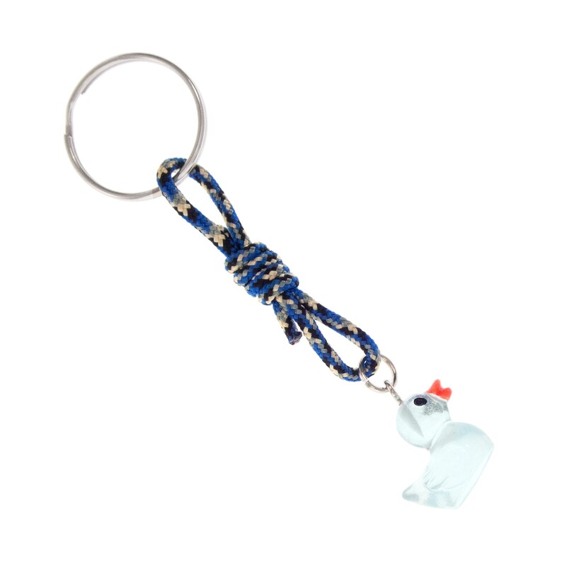 May include: A keyring featuring a silver metal ring attached to a knotted cord in a blue, black, and tan woven pattern. The cord connects to a small, translucent light blue duck charm with a bright orange beak and a black eye detail.