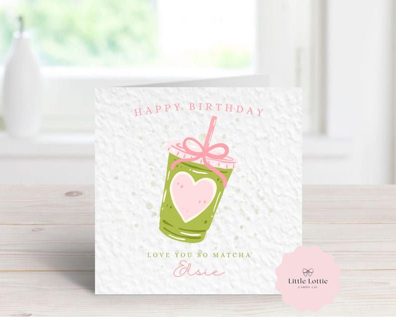 K&ouml;nnte beinhalten: Quadratische Geburtstagskarte mit einer Illustration eines gr&uuml;nen Matcha-Getr&auml;nks, einem rosa Herz und einer rosa Schleife. Die Karte tr&auml;gt die Aufschriften "Happy Birthday" und "Love You So Matcha" mit einem Namen darunter. Das Little Lottie-Logo befindet sich unten rechts.