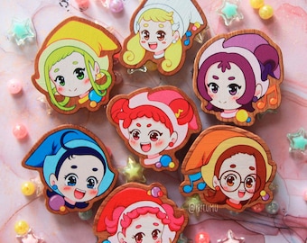 May include: Set of eight wooden character pins featuring colorful cartoon faces with different expressions. Each pin has a musical note and a few colorful dots. The pins are on a pink and white marble background.