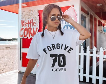 Puede incluir: Camiseta blanca de gran tamaño con texto negro que dice "FORGIVE 70 XSEVEN".