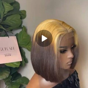 May include: A short bob wig with a dark brown base and blonde highlights. The wig is styled with a straight, blunt cut and has a natural-looking hairline.