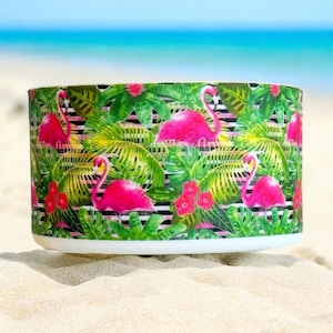 May include: A white ceramic bowl with a tropical print featuring pink flamingos, green palm leaves, and black and white stripes.