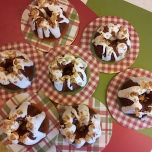 Puede incluir: Seis mini bundt cakes con glaseado blanco y nueces picadas en la parte superior, dispuestos en platos a cuadros rojos y blancos.