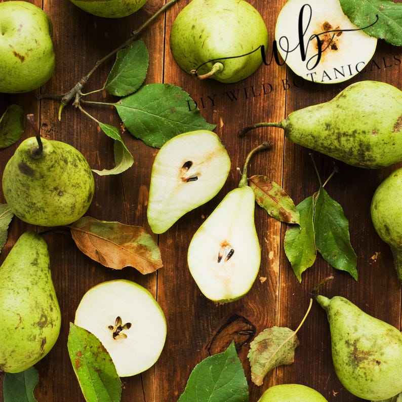 K&ouml;nnte beinhalten: Eine Draufsicht auf gr&uuml;ne Birnen auf einer Holzoberfl&auml;che. Einige Birnen sind ganz, w&auml;hrend andere halbiert sind und die hellbraunen Kerne im Inneren zeigen. Gr&uuml;ne Bl&auml;tter sind um die Birnen herum verstreut.
