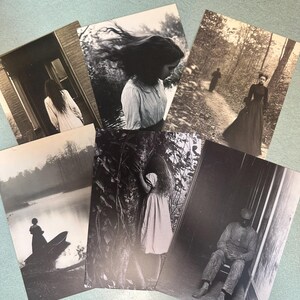 Puede incluir: Una colección de postales vintage en blanco y negro con escenas de figuras en varios entornos. Las imágenes representan a personas en entornos exteriores e interiores, con un enfoque en composiciones atmosféricas y artísticas. Las postales tienen un tono sepia.