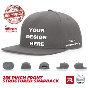 May include: A charcoal gray structured snapback cap with a flat brim. The front panel features the white text YOUR DESIGN HERE. The side of the cap includes the white text Side embroidery. Five smaller views of the cap are shown below the main image.