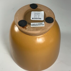 Pu&ograve; includere: Un'urna in ceramica di colore terracotta con una base rotonda e un'ampia apertura. L'urna ha un'etichetta sul fondo che recita "terrain 34275677 CHALK URN 14,00 &euro;" e "MADE IN VIETNAM FABRIQUE AU VIETNAM".