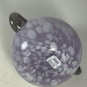 May include: A purple glass bowl with white speckles and a grey handle. The bowl is labelled "Anthropologie" and has a price tag of &pound;58.00 GBP and &pound;68.00 CAD.