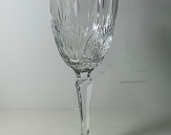 May include: A clear glass wine glass with a gold rim and a cut crystal design.