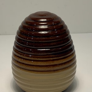 May include: A set of three ceramic mugs with a speckled, matte finish. The mugs are in shades of cream, light gray, and dark gray. Each mug has a simple, minimalist design and a rounded handle.