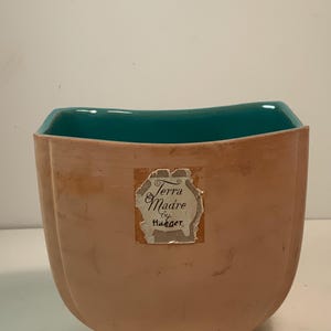 以下が含まれることがあります： ヴィンテージのHaeger Terra Madre陶器の花瓶。花瓶は、外側がピーチ色で、内側がティール色です。前面のラベルには「Terra Madre by Haeger」と書かれています。