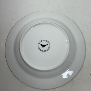May include: White ceramic plate with a black bird logo that reads "Hand Wash Recommended Made in Indonesia Fabriqu&eacute; en Indon&eacute;sie".