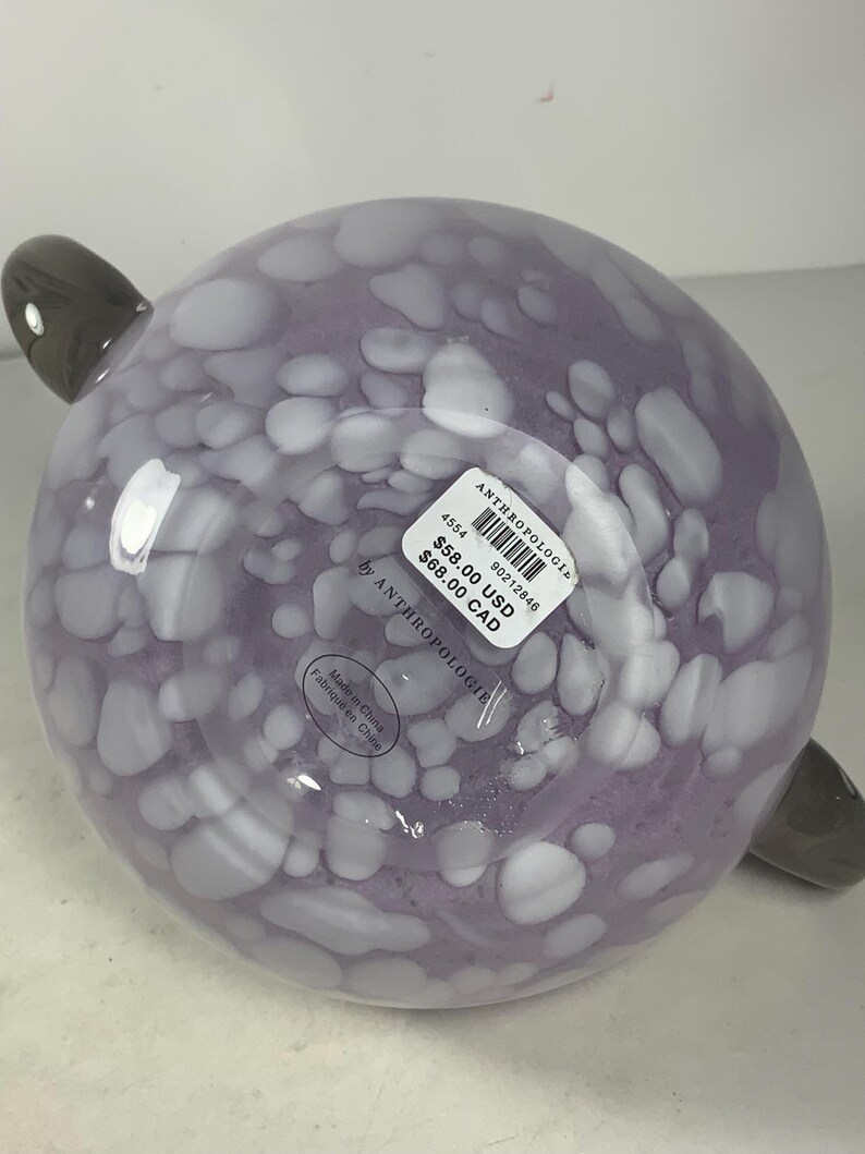 May include: A purple glass bowl with white speckles and two grey handles. The bowl is labelled "Anthropologie" and has a price tag of &pound;58.00 and &pound;68.00.