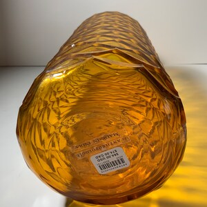 May include: Amber glass vase with a textured, geometric pattern. The vase is labelled "Anthropologie" and "Made in India" with a price tag of &pound;24.00.