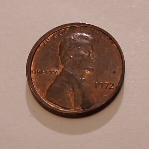 May include: A copper-colored 1972 US penny with the profile of Abraham Lincoln and the words "LIBERTY" and "IN GOD WE TRUST" visible.