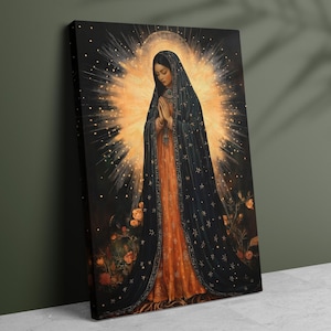May include: A canvas print of a religious figure with a halo, wearing a dark blue cloak adorned with gold stars over an orange dress. The figure is in prayer, with a radiant light emanating from behind. Roses are at the bottom.