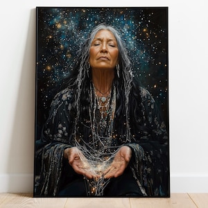 Puede incluir: Una impresión artística enmarcada representa a una persona mayor con cabello largo y gris, ojos cerrados y manos extendidas, sosteniendo hebras brillantes. El fondo es un espacio azul oscuro lleno de estrellas. La persona lleva una túnica oscura estampada y collares.