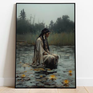 Könnte beinhalten: Ein gerahmter Kunstdruck zeigt eine Person in einem cremefarbenen Gewand, die in einem Teich mit Seerosen sitzt. Die Person hat lange dunkle Haare und trägt Schmuck. Der Hintergrund zeigt eine neblige Landschaft mit Bäumen und hohem Gras.