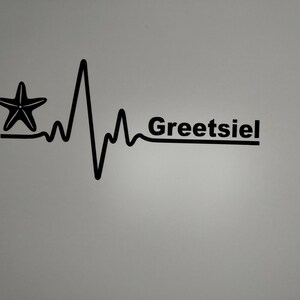 Peut inclure: Graphique noir et blanc d'un battement de cœur stylisé avec une étoile de mer au début de la ligne. Le texte "Greetsiel" est à la fin de la ligne.