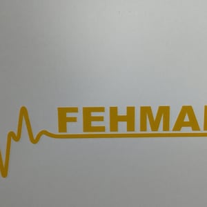 Puede incluir: Un ancla dorada con un gráfico de latido del corazón y la palabra "FEHMARN" en letras doradas.
