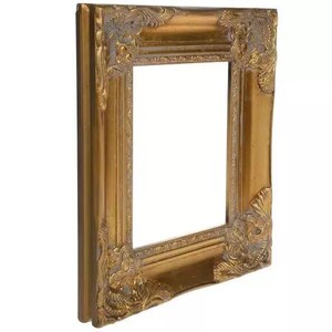 May include: A rectangular picture frame with a metallic gold finish. The frame features ornate, raised scrollwork and floral relief detailing at each of the four corners, with a smooth, recessed inner border and a thick, stepped outer edge profile.